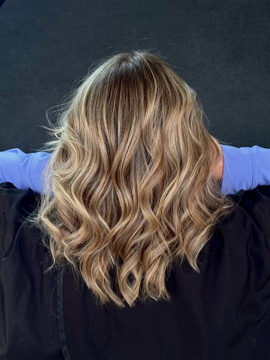 Shoulder-length bronde hair with honey blonde ribbons and defined waves, photographed from behind