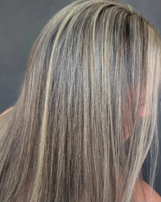 Fine blonde highlights blended through brunette hair on a real client