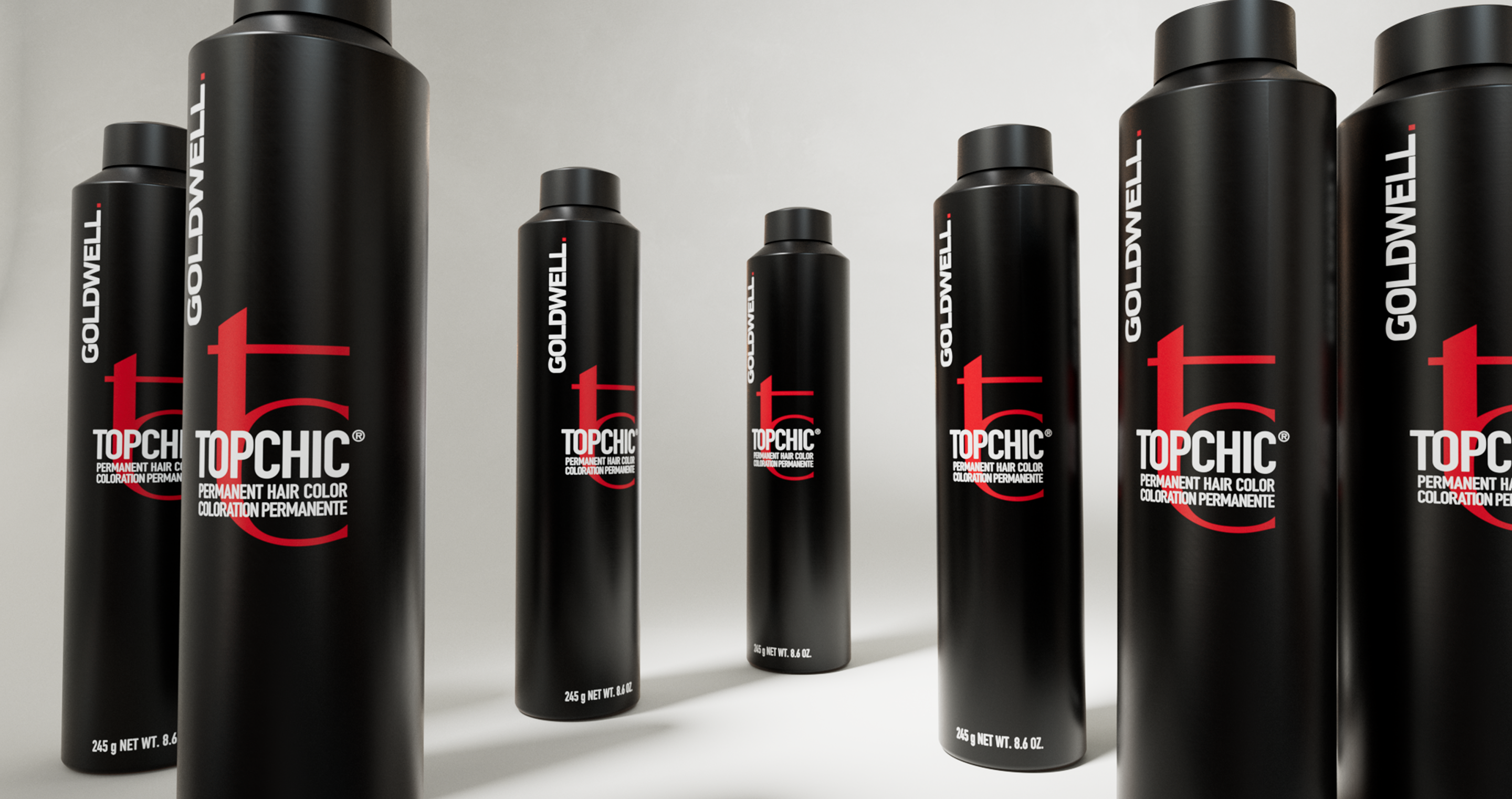 Goldwell Topchic permanent hair color bottles standing on a light gray studio floor, product photo