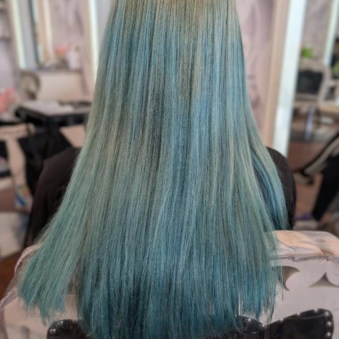 Before: long teal hair that has faded unevenly to a washed-out green-blue, photographed from the back